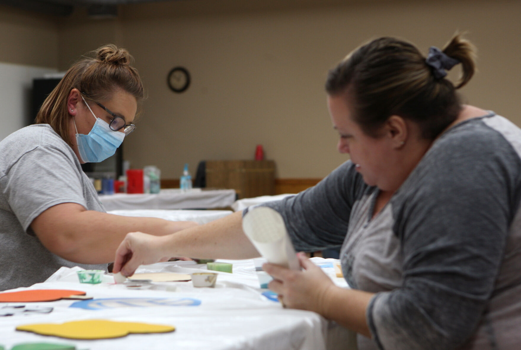 Emily Mills helps Dana Keence paint